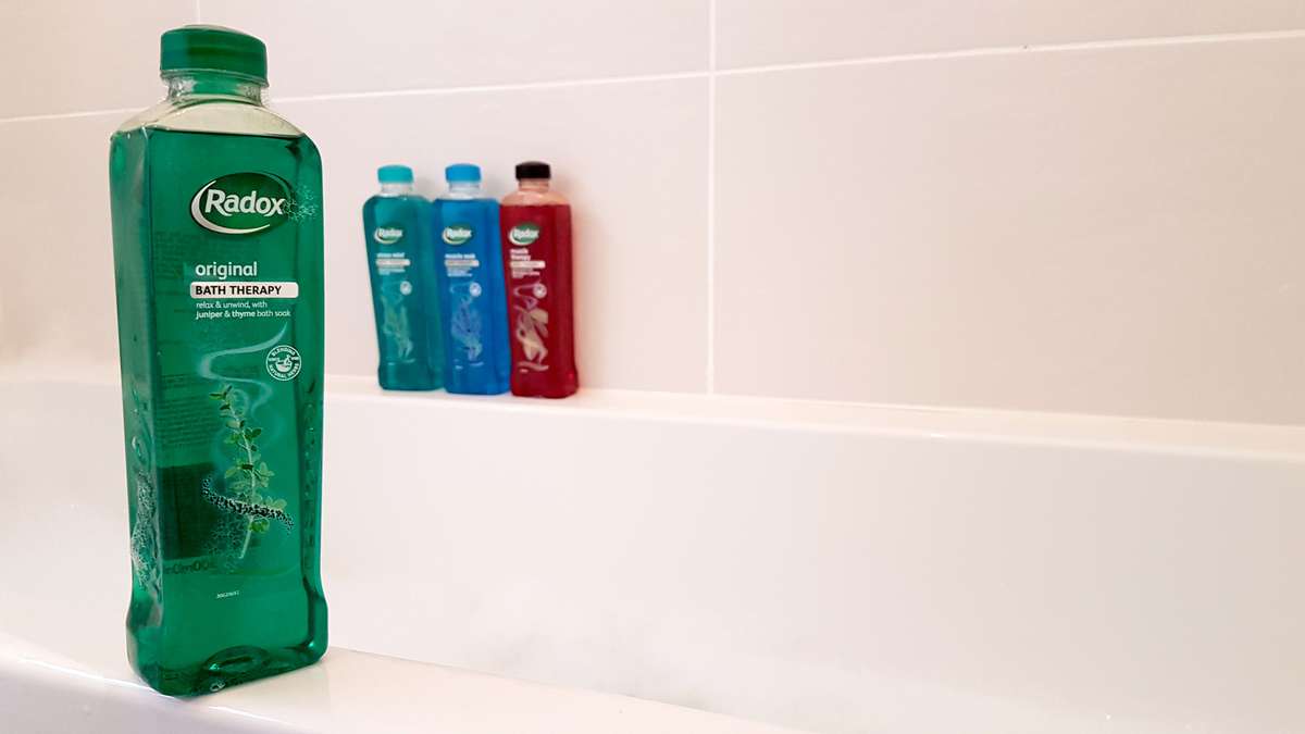 Radox shower gel bottle on edge of bath tub