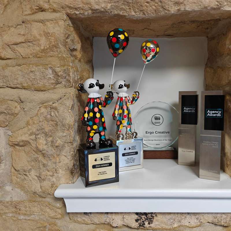 A shelf space in a wall with 5 awards displayed upon it